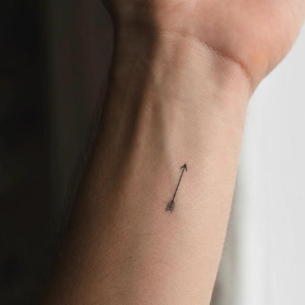 idée tatouage discret homme petite flèche minimaliste, photo réaliste sur peau