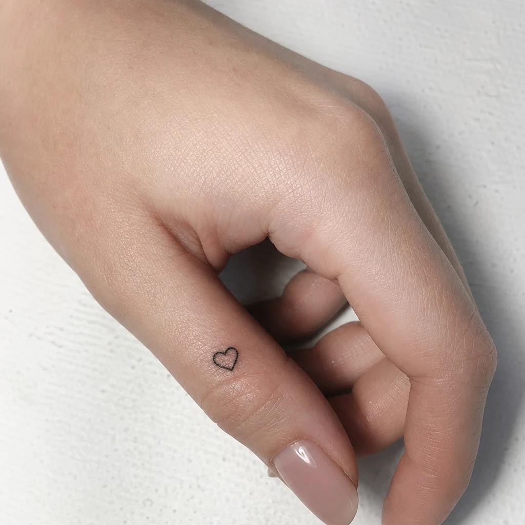 idée tatouage doigt femme cœur minuscule, photo réaliste sur peau
